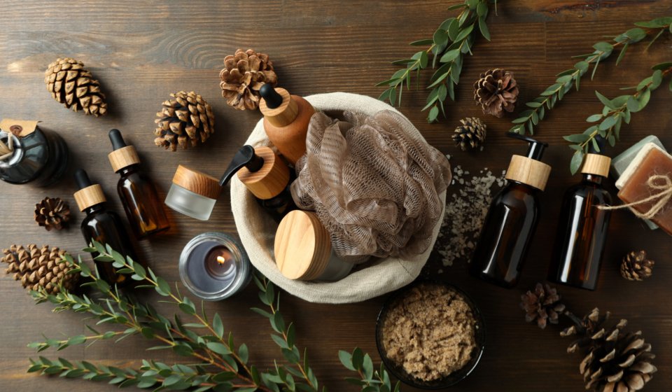Concept of gift with basket of cosmetics on wooden background